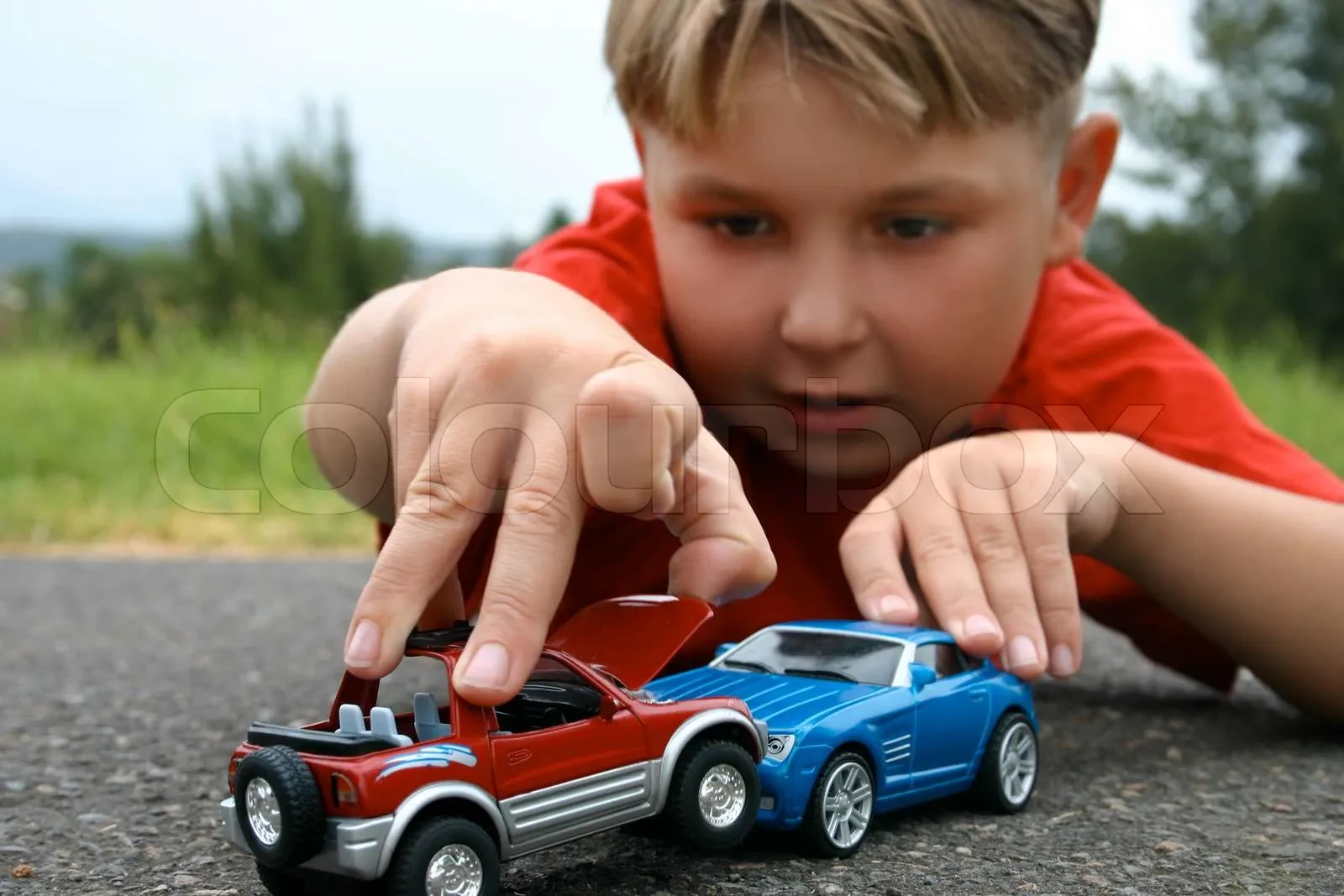 Child playing with Kinsmart cars